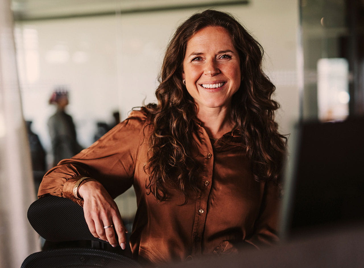 Smilende ejendomsmægler portræt på kontor i Nybolig