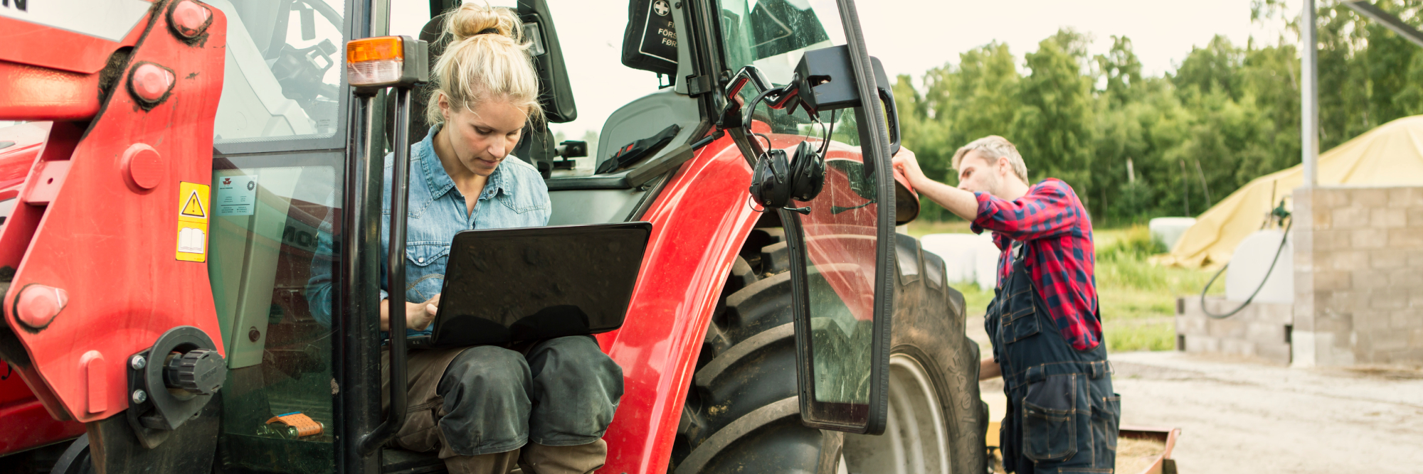 kvinde på computer sidder i traktor