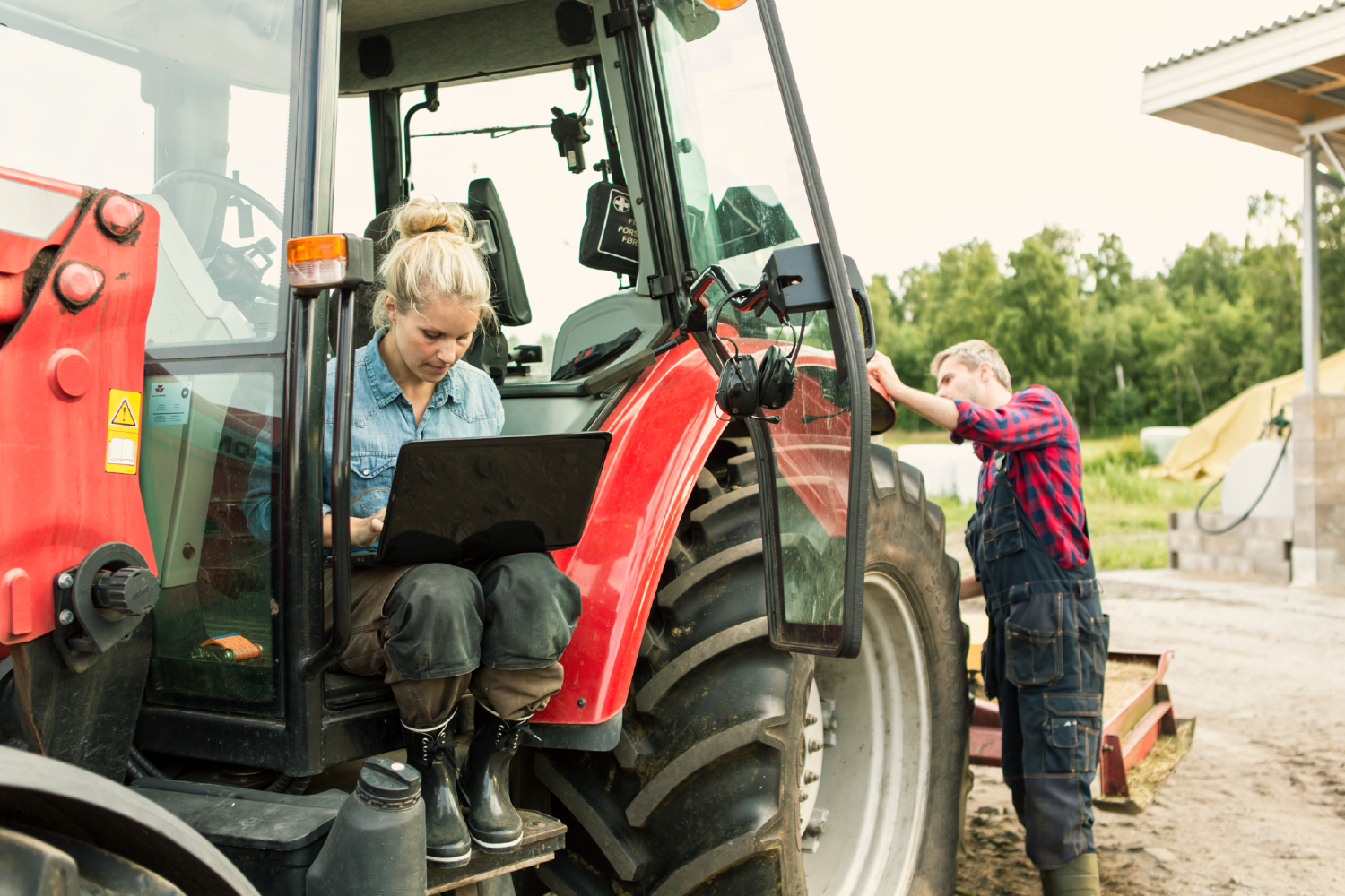 kvinde på computer sidder i traktor